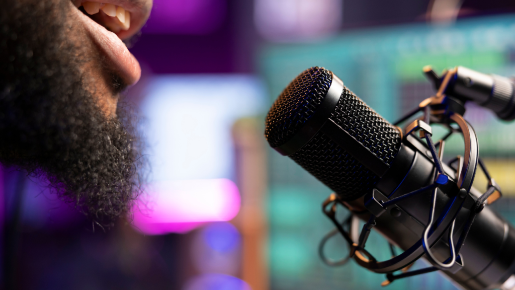 Man with beard speaking into a microphone.