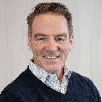 Smiling man with brown hair and blue eyes.