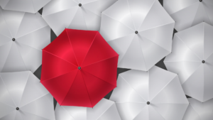A red umbrella in a sea of white umbrellas, overhead view